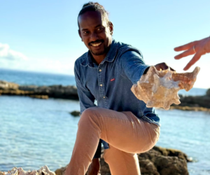 Rody TOLASSY, Député Européen, tenant un lambi, symbole de la culture et de l'identité guadeloupéenne